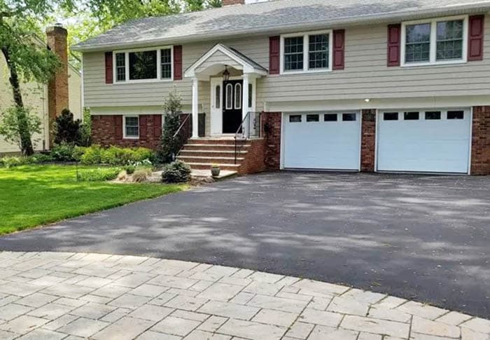 Asphalt and paver, white portch and two-door garage