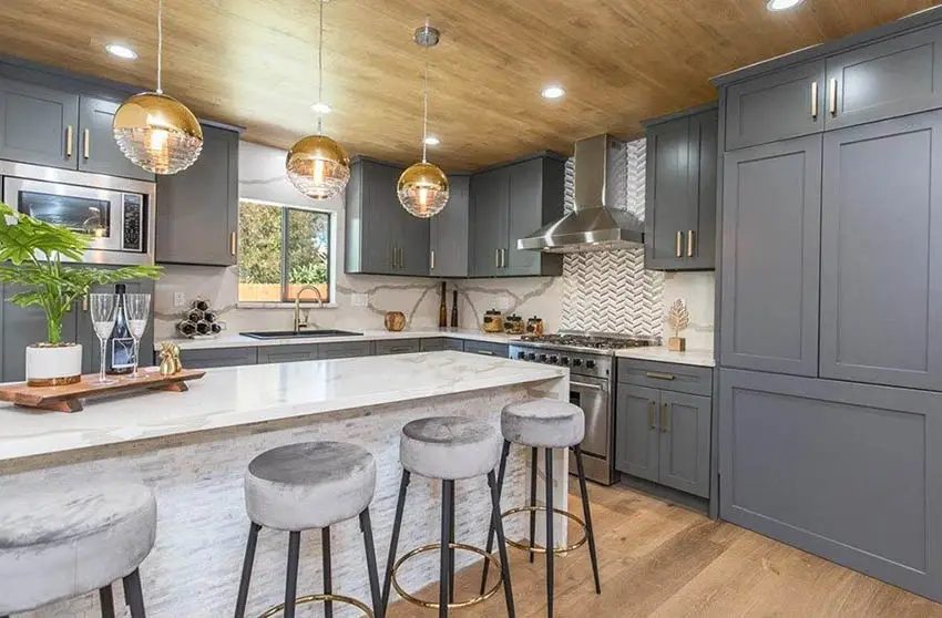 Beautiful kitchen with dark gray cabinets gold accent hardware quartz countertops and backsplash