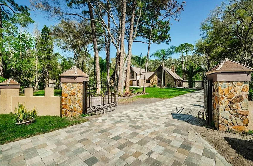 Driveway with stone clad columns and metal gate