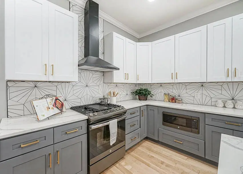 Contemporary kitchen with white and dark gray cabinets with gold hardware pattern tile backsplash
