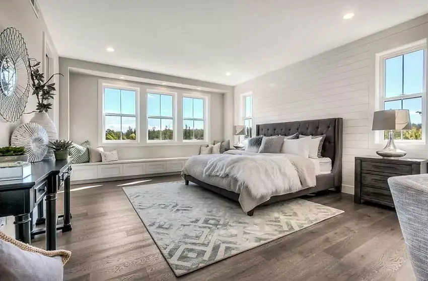 Contemporary master bedroom with long window seat bench shiplap accent wall
