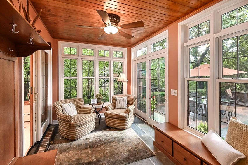 Craftsman style 4 season room with ceiling fan and window sitting bench