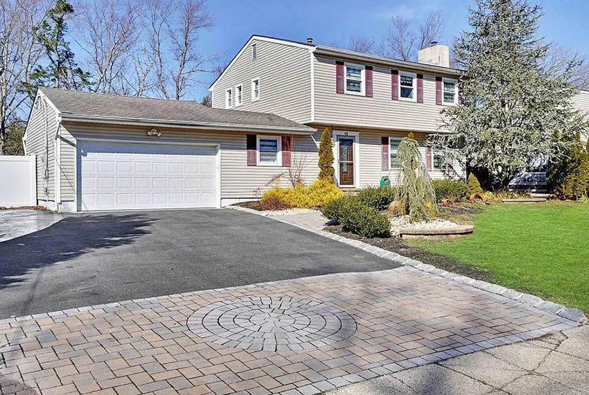 Home with asphalt and paver driveway