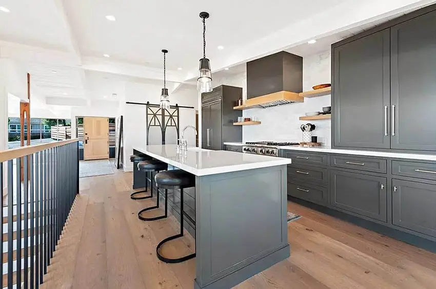 Kitchen with dark gray painted cabinets white quartz countertops wood flooring