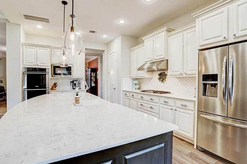 Kitchen with recessed lighting, steel appliances and diagonal tile backsplash