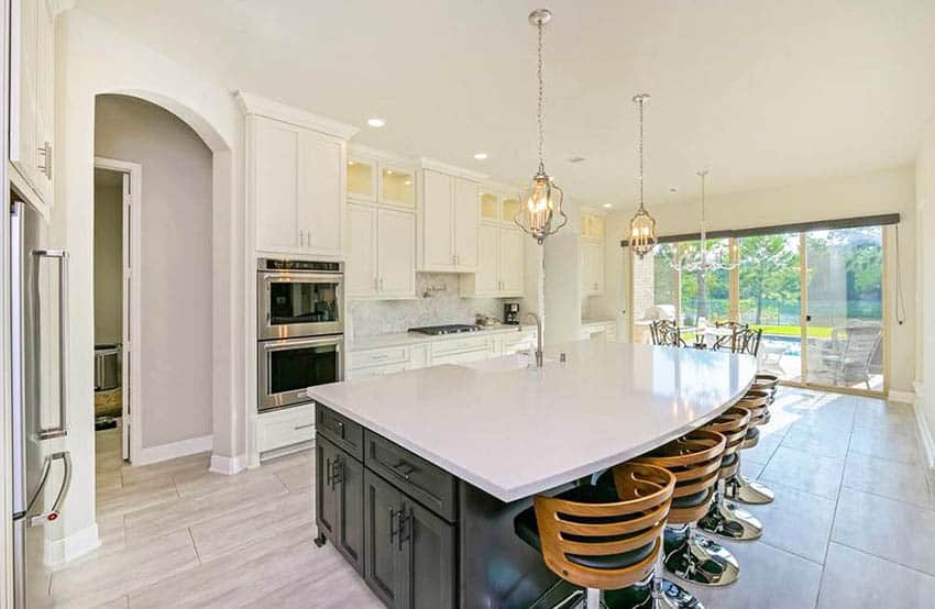 Large kitchen with silestone countertops black island white cabinets wood bar stools