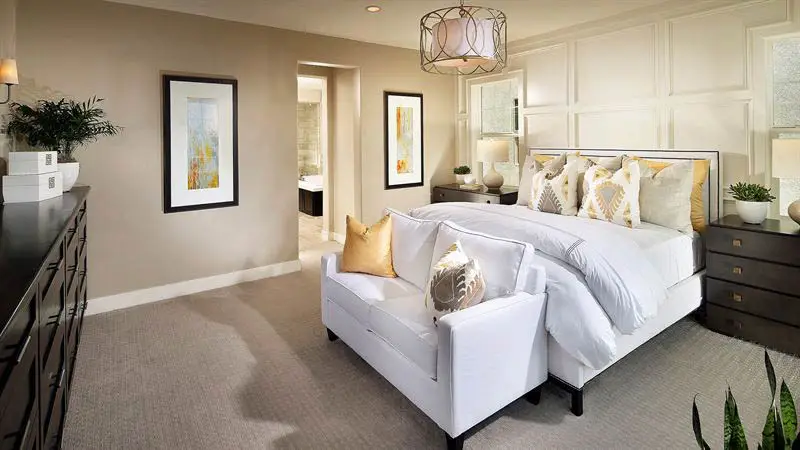 Master bedroom with love seat at foot of bed