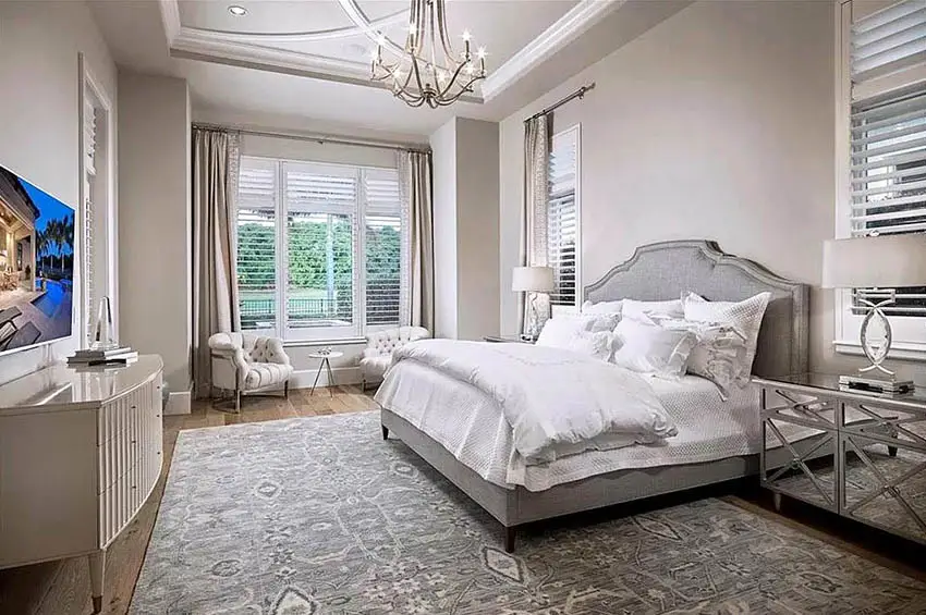 Master bedroom with tufted armchairs sitting area