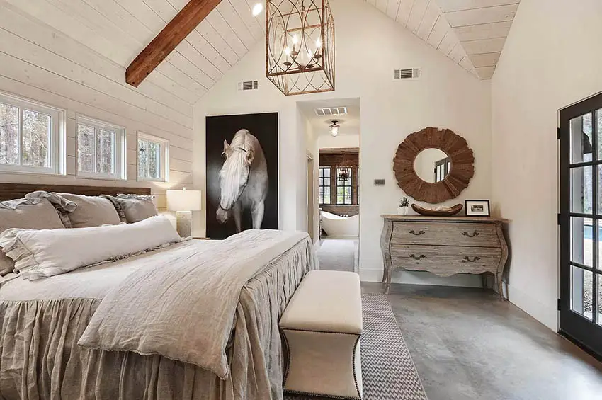 Modern farmhouse bedroom with gabled ceiling with beams shiplap walls concrete flooring