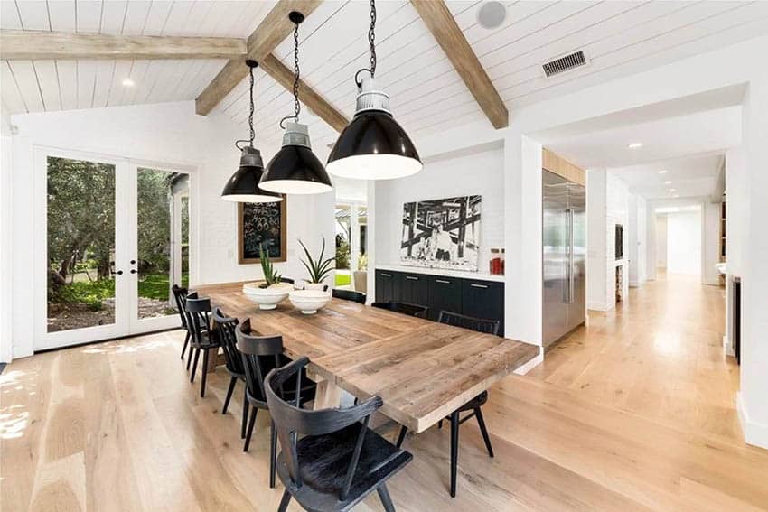 Modern farmhouse dining room with vaulted ceiling wood beams pendant lighting wood floors