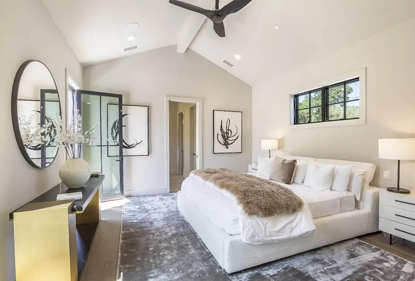 Modern farmhouse master bedroom with high ceiling large area rug black window door frames off white paint 