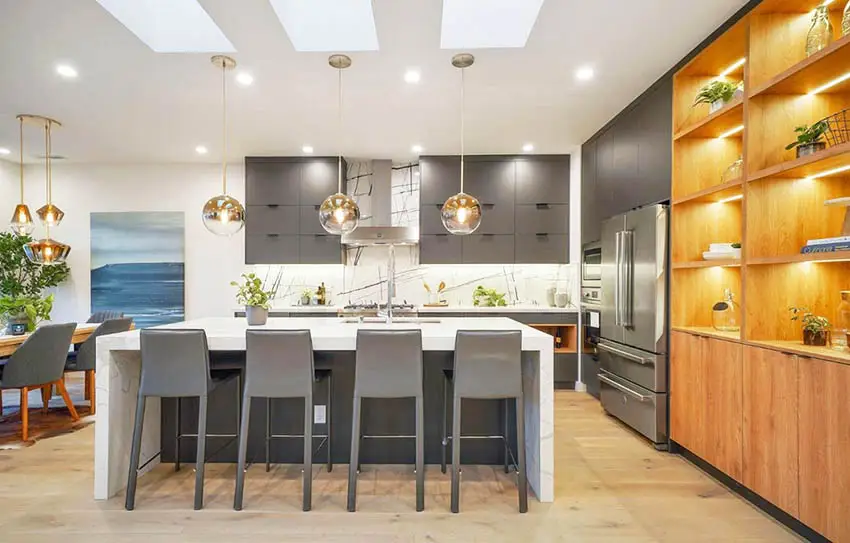 Modern kitchen with dark gray cabinets gray island with white quartz waterfall countertop