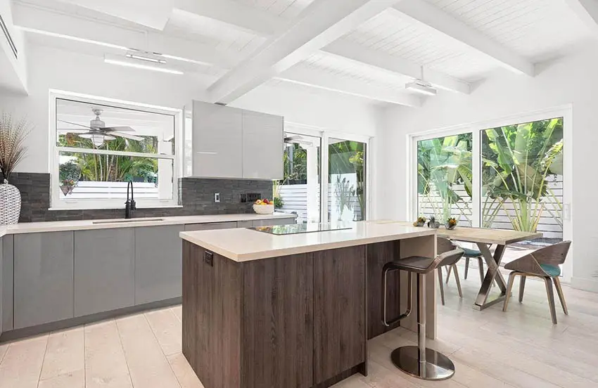 Kitchen with brown island, white framed windows and coffered ceiling