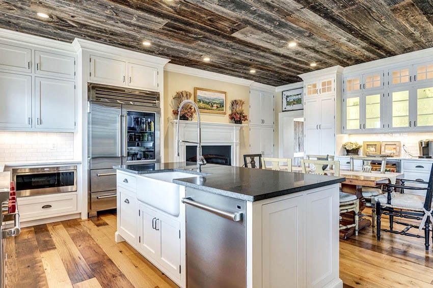 Open concept kitchen with American chestnut reclaimed wood flooring wood ceiling white cabinets