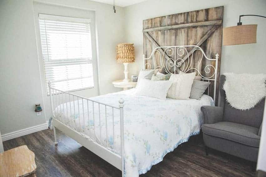 Small bedroom with reclaimed wood headboard and accent chair