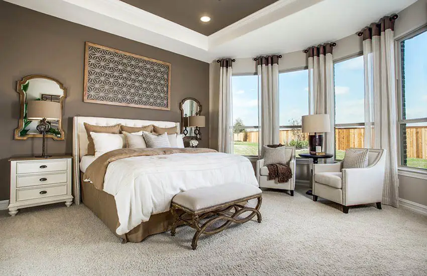 Staged master bedroom with dark brown paint and sitting area
