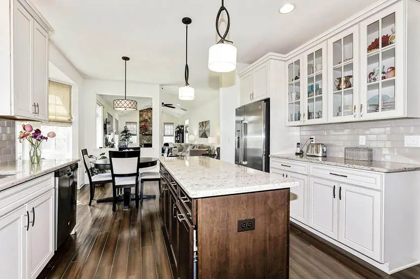 Kitchen with whtie countertops, drum lights, round table and chairs