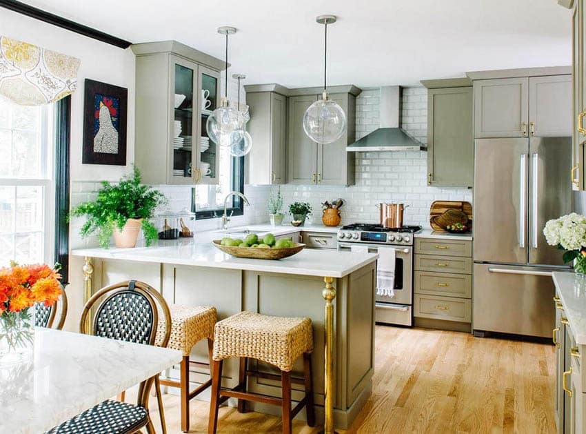 Transitional kitchen with light green cabinets silestone countertops subway tile backsplash and wood flooring