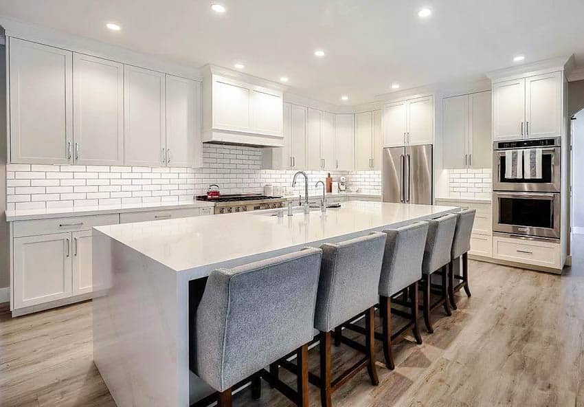 Kitchen with white silestone countertops, white cabinets and subway tile wood flooring