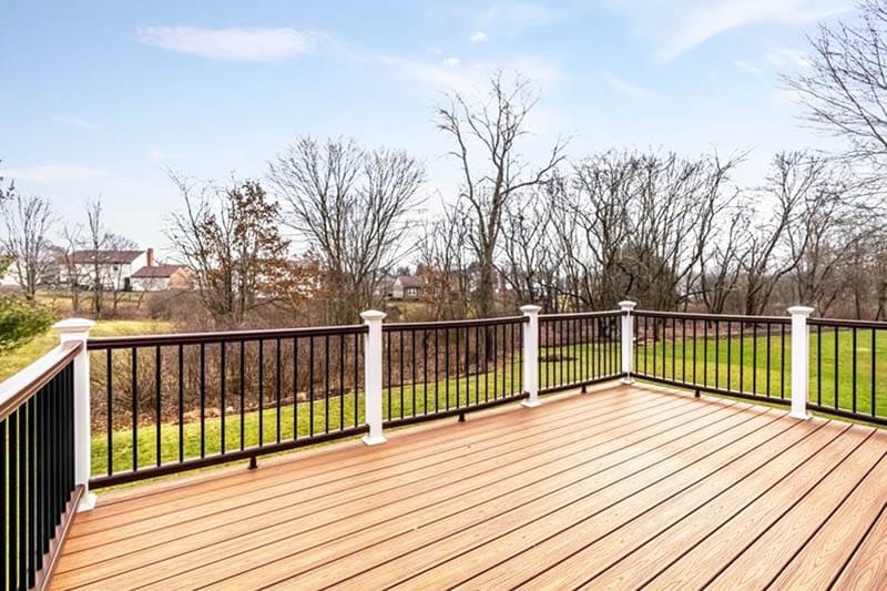 Trex deck with white railing supports with caps and black guard rail