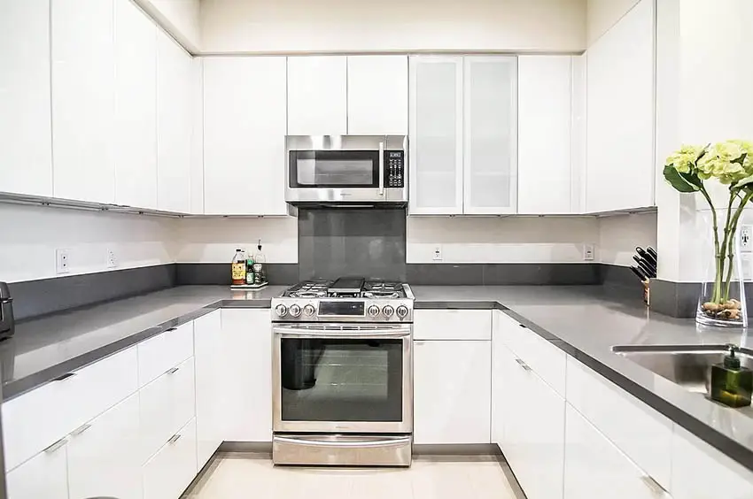U shaped kitchen with dark gray caesarstone countertops white cabinets