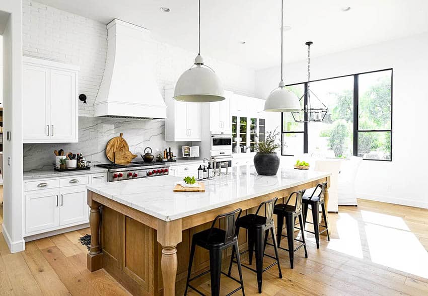 Chefs kitchen with marble and quartz counters, white cabinets, pendant lights and backsplash
