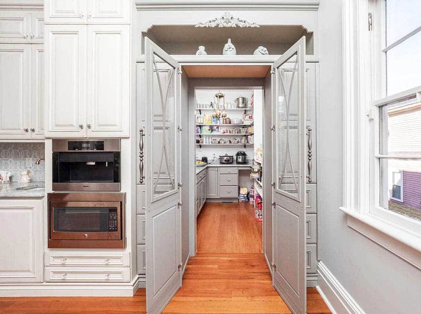 Chefs kitchen with walk in pantry with cabinets