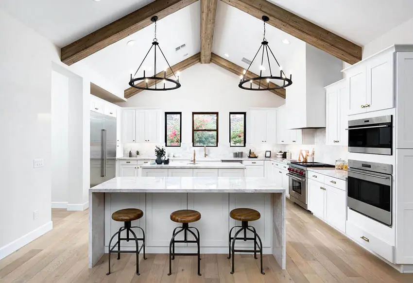 Contemporary kitchen with cathedral ceiling and open wood beams white cabinets quartz counters