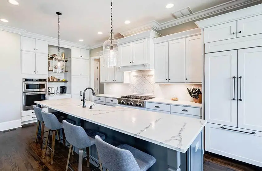 Kitchen with white quartz with gray veining countertops white cabinets gray island