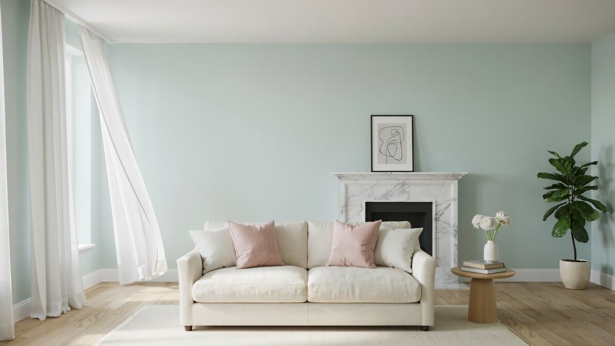 Pale green living room with white marble fireplace and blush pink accent pillows