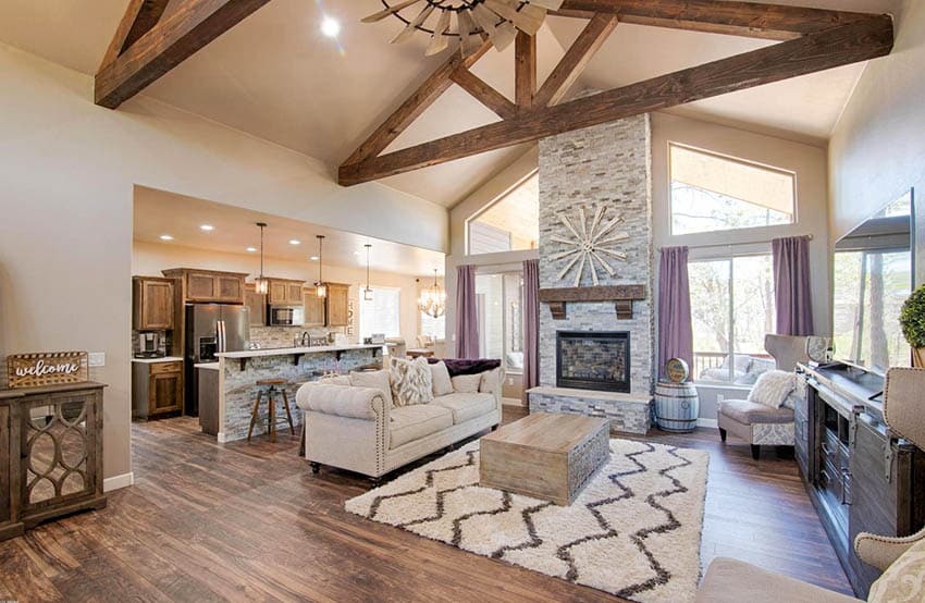 Living room with cathedral ceiling wood beams stacked stone fireplace