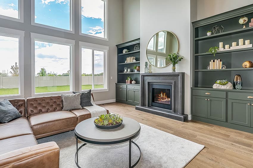 Room with leather couch, built in cabinet and fireplace