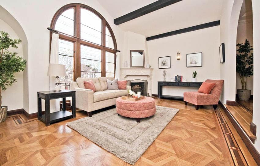 Living room with parquet floors, open beam ceiling and arched windows