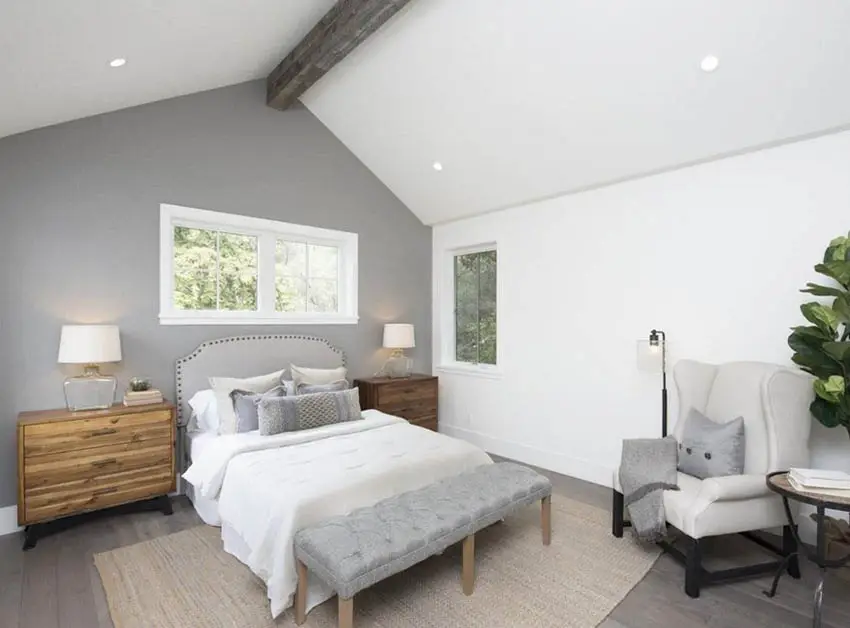Master bedroom with cathedral ceiling wood beam and gray accent wall
