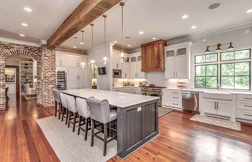 Kitchen with grey island breakfast bar. pendant lights and brick doorway