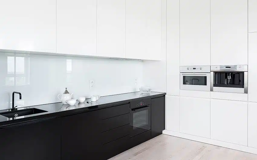 Modern kitchen with backpainted black glass countertops white and black cabinets