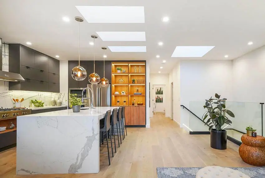 Modern kitchen with waterfall quartz countertop island dark gray cabinets