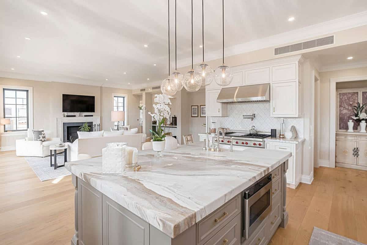 L shape kitchen and gray island with marble counters