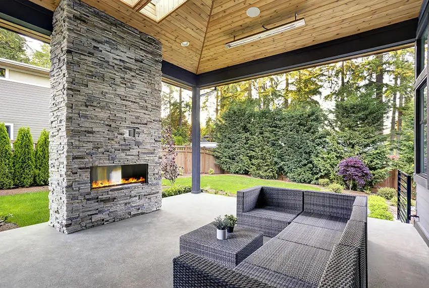 Patio with grey furniture, beadboard ceiling and fireplace
