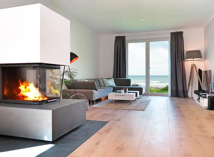 Three sided fireplace in room with ocean views