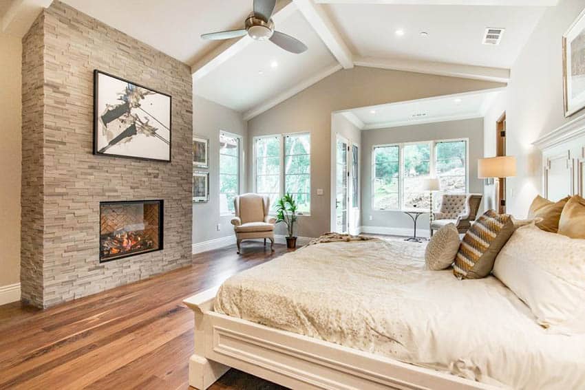 Traditional master bedroom with cathedral ceiling and fireplace