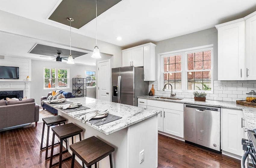 Transitional kitchen with white granite surfaces, white shaker cabinets, subway tile and gray paint