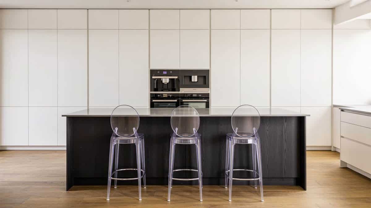 Ultra-modern kitchen with black toned island and white flat face cabinets