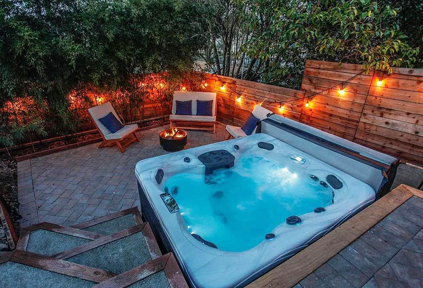 Backyard hot tub with paver patio and fire pit