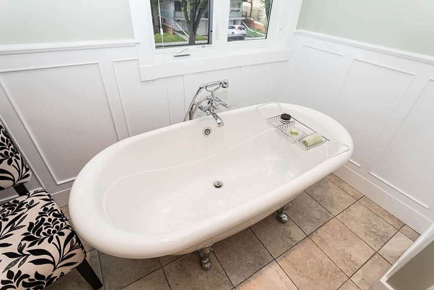 Bathroom with beige floor tile, white wainscoting and light green sage paint