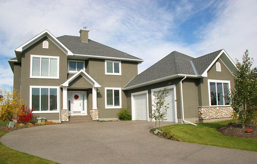 Green stucco facade of a home with white trimmings