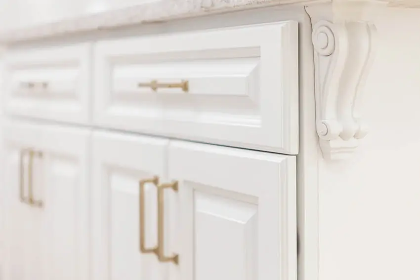 Kitchen with raised panel cabinets with gold hardware close up