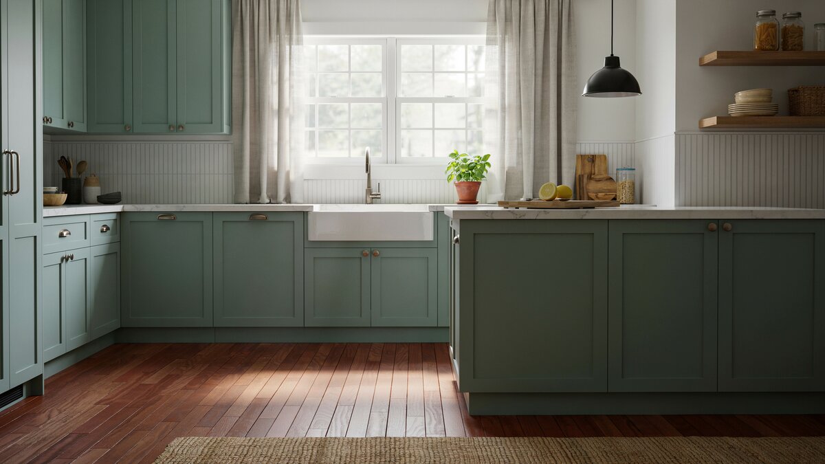 Farmhouse kitchen with sage green shaker cabinets, farmhouse sink and cherry plank floor