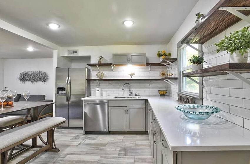 Kitchen with interlocking floor tiles gray cabinets open shelving bench seat dining table