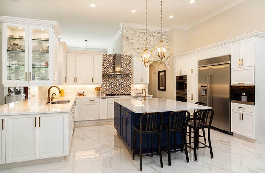 Kitchen with marble floor tiles, white cabinets and dark blue island